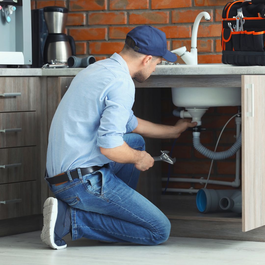 a plumber working on a kitchen sink