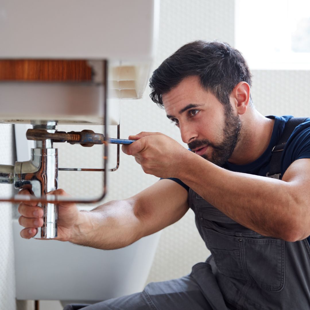 a plumber working on a bathroom sink