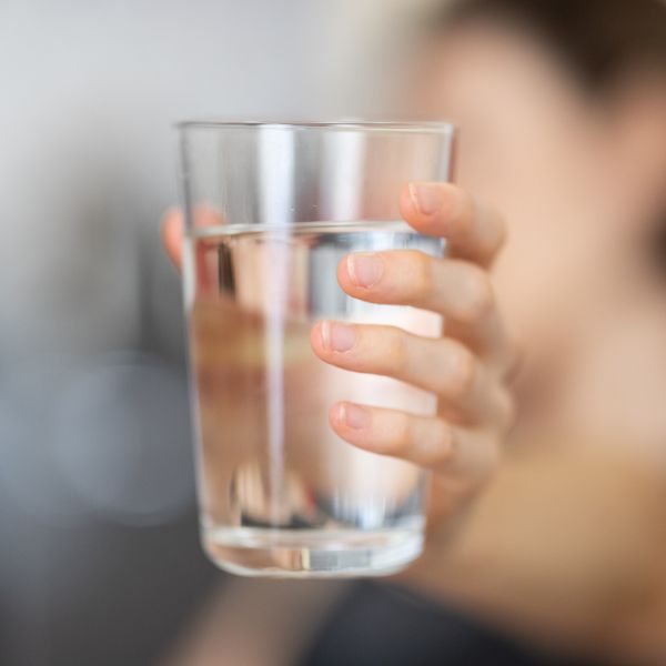 A woman holding a clean glass of water