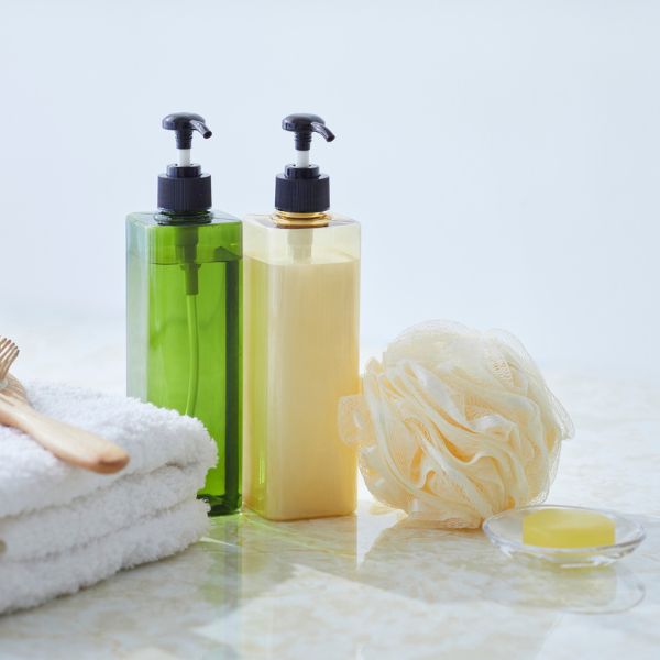 Soap and shampoo bottles and a towel, brush, and loofa.